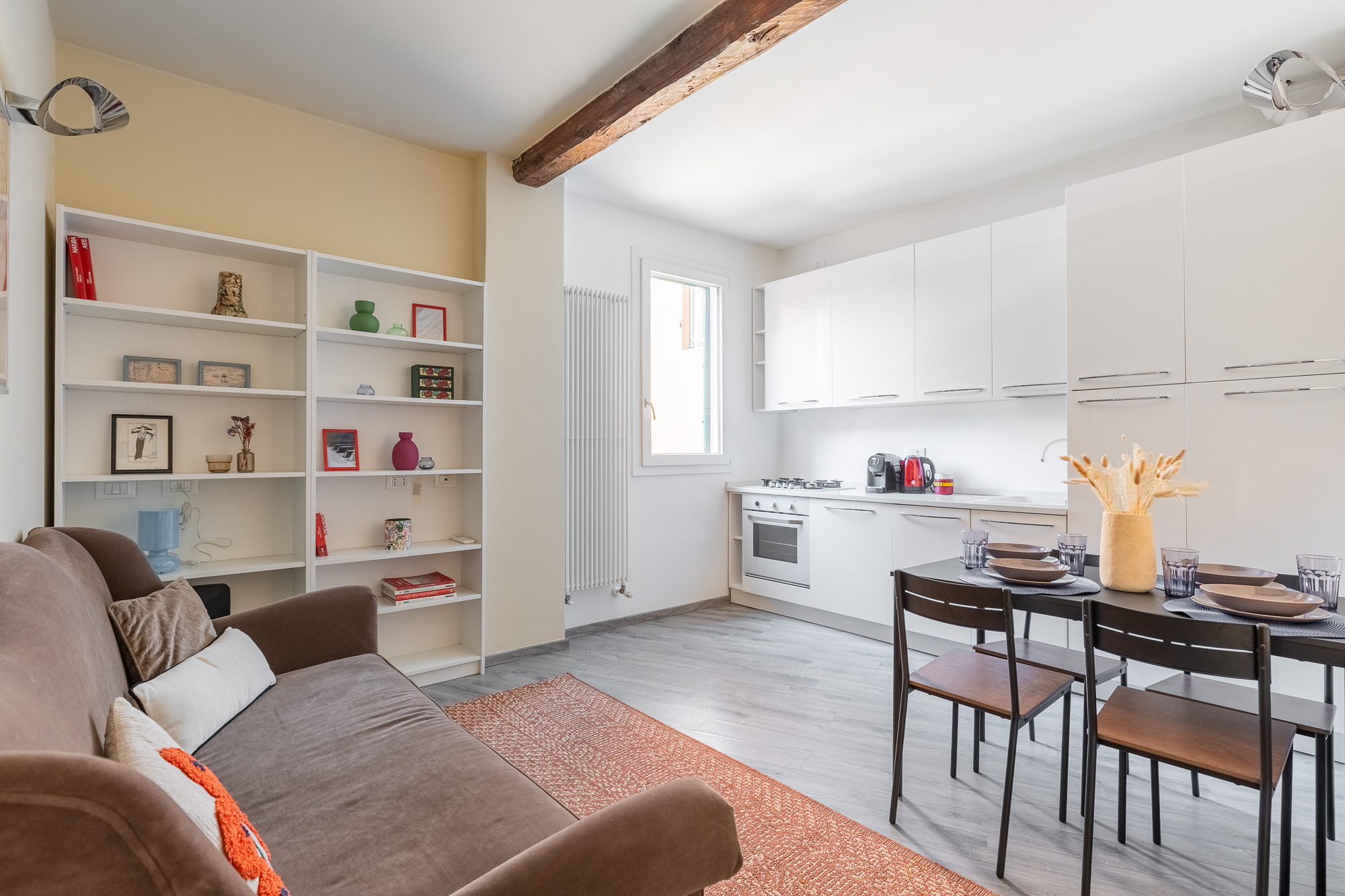 Elegante zona living open space con cucina attrezzata, ambienti luminosi e dettagli di charme nel centro di Bologna. Urban Nest - appartamenti e case vacanze a Bologna