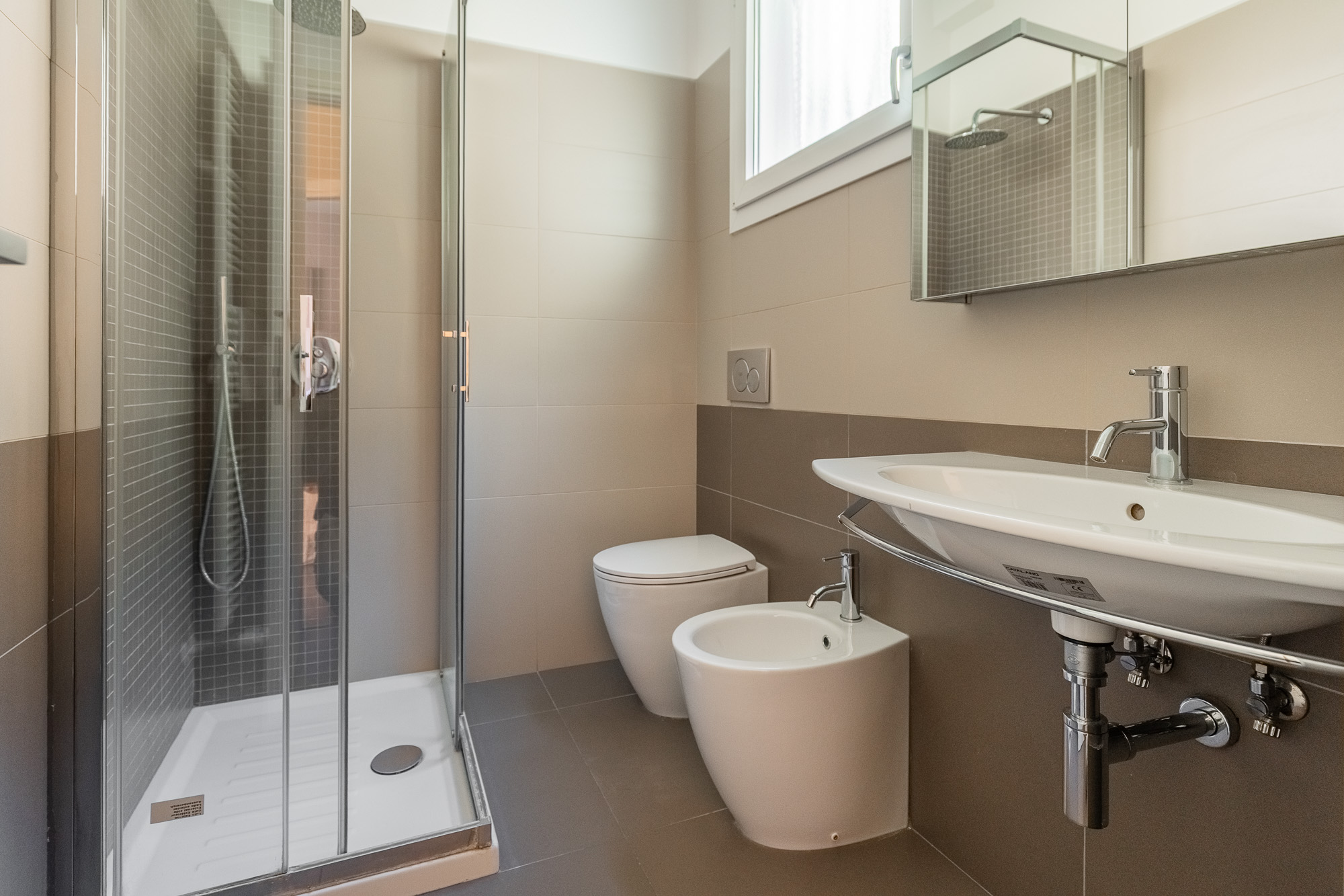 Bagno moderno e luminoso con ampia doccia, comfort e funzionalità in elegante bilocale nel cuore di Bologna. Urban Nest - appartamenti e case vacanze a Bologna
