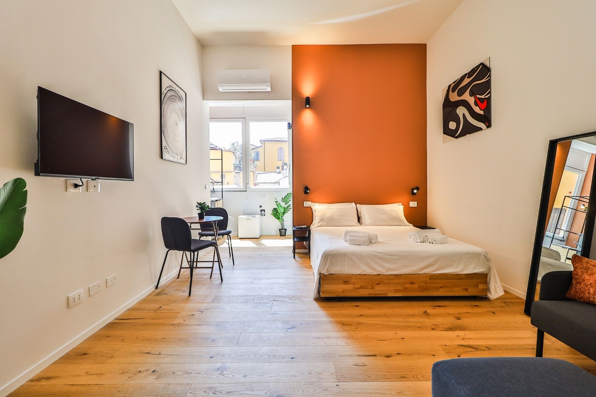 Camera matrimoniale con parete arancione — Urban Nest - appartamenti e case vacanze a Bologna