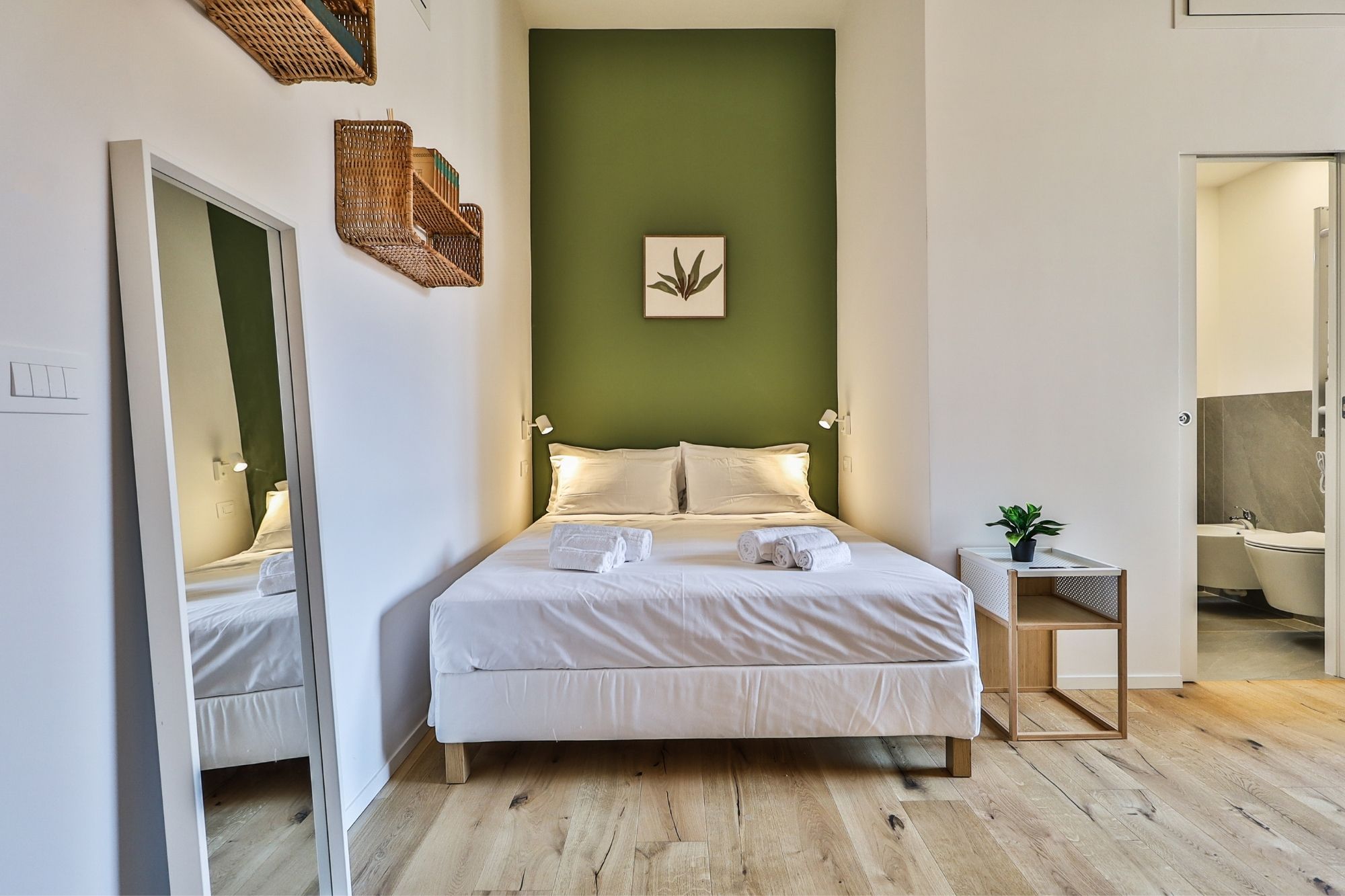 Camera matrimoniale con parete verde — Urban Nest - appartamenti e case vacanze a Bologna